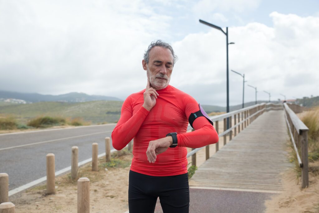 Older male adult checking his pulse after a run. He is participating in occupational testing to be sure that he is physically fit for duty. 